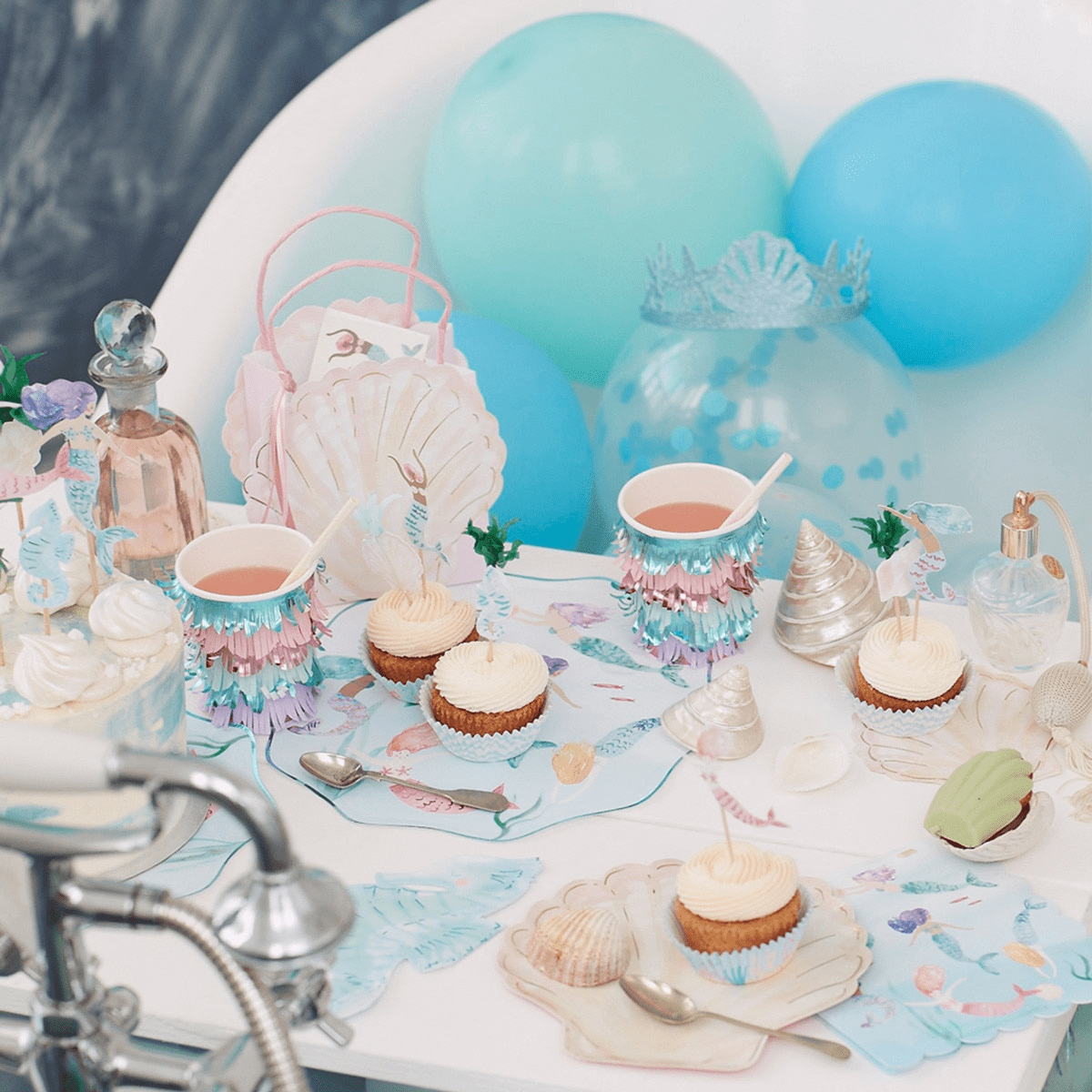 Pastel mermaid birthday table decor with cupcakes and blue balloons from Parte Haus party supply store in Bethesda Maryland