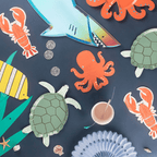 colorful under the sea theme plates and decorations with shark octopus turtle crab fish from Parte Haus party supply store in Bethesda Maryland