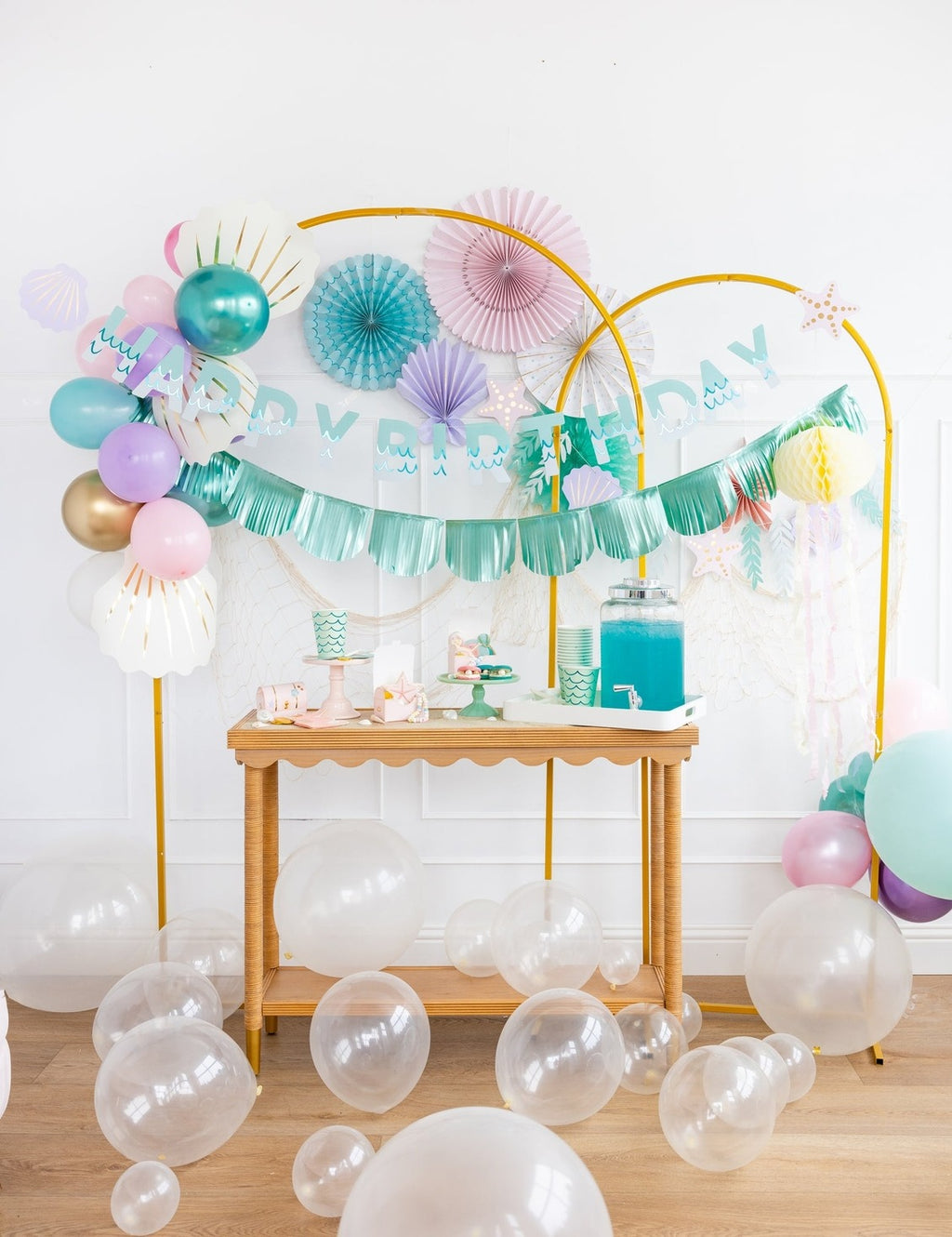 Blue and pastel birthday banner balloon and shell decorations under the sea theme from Parte Haus party supply store in Bethesda MD