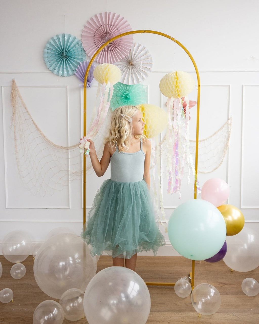 Pastel balloon arch and fans birthday party decoration with little girl from Parte Haus party supply store in Bethesda MD