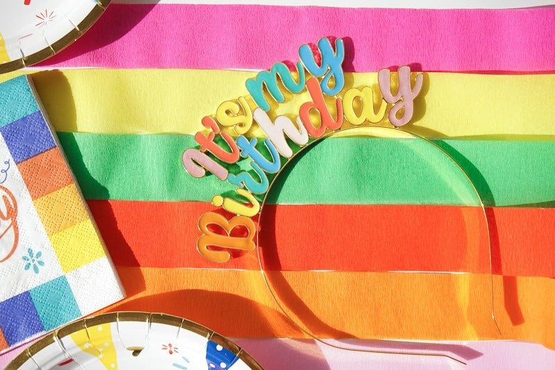 Multicolor It's My Birthday headband on rainbow backdrop birthday theme from Parte Haus party supply store in Bethesda Maryland