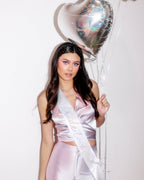 Pink satin bride to be sash and silver heart balloon for bachelorette from Parte Haus party supply store in Bethesda MD